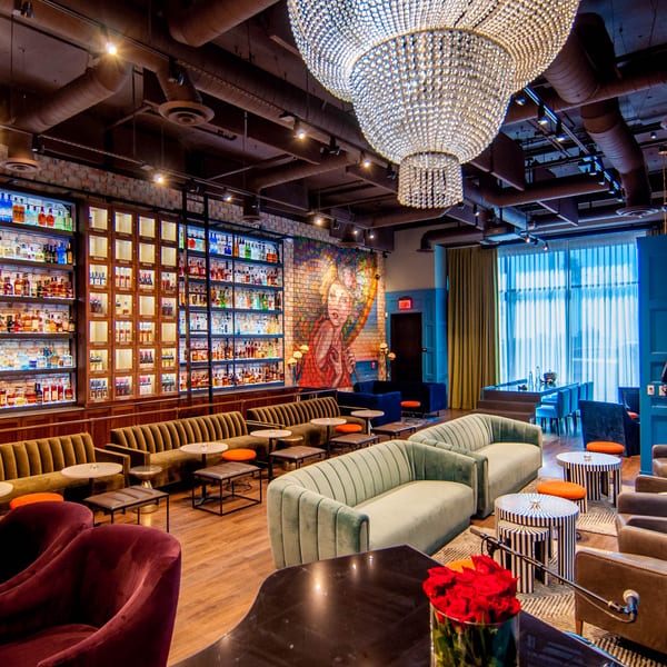 A luxurious lounge with plush seating, a large crystal chandelier, and a well-stocked bar.
