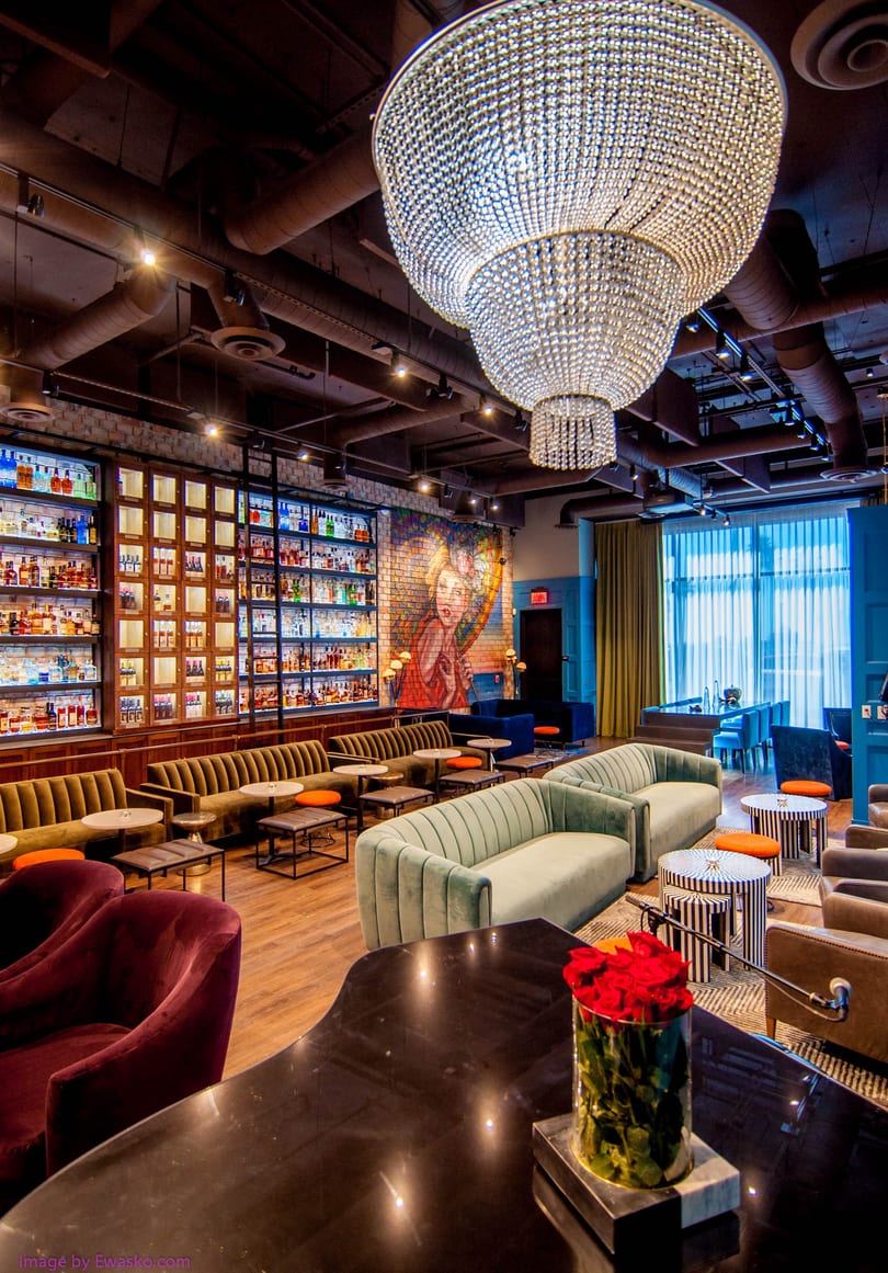 A luxurious lounge with plush seating, a large crystal chandelier, and a well-stocked bar.